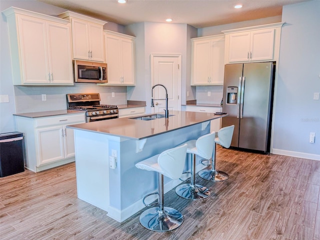 1047 Oak Bluff Dr, Davenport, FL 33837 - kitchen featuring stainless steel appliances, white cabinetry, a kitchen island with sink, and recessed lighting