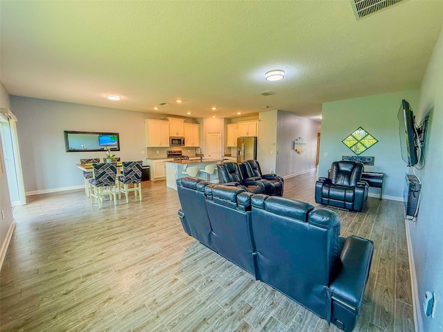 1047 Oak Bluff Dr, Davenport, FL 33837 - living room featuring light wood-style floors, recessed lighting, and a textured ceiling