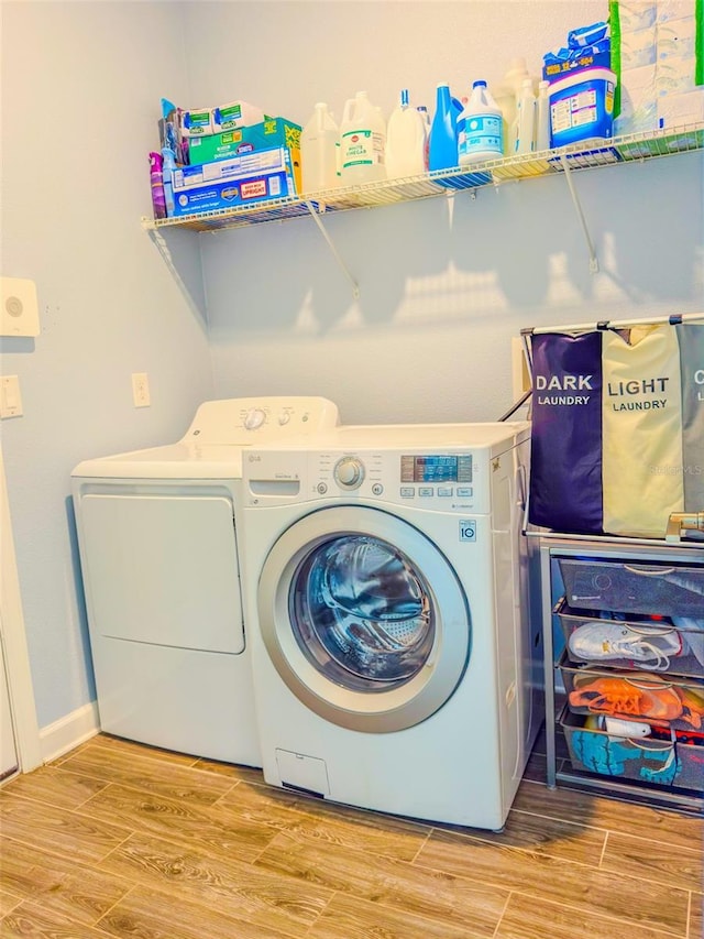 1047 Oak Bluff Dr, Davenport, FL 33837 - laundry room with washing machine and dryer and wood finished floors