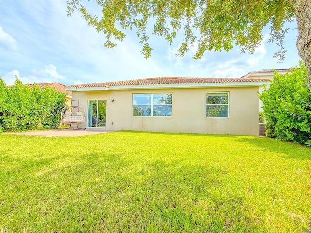 1047 Oak Bluff Dr, Davenport, FL 33837 - back of house with stucco siding, a patio, a tile roof, and a yard