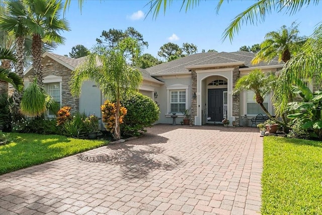 4080 Safflower Ter, Oviedo, FL 32766 - ranch-style home with stone siding, stucco siding, a front yard, and an attached garage