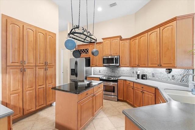 4080 Safflower Ter, Oviedo, FL 32766 - kitchen with stainless steel appliances, backsplash, a center island, a towering ceiling, and light tile patterned floors