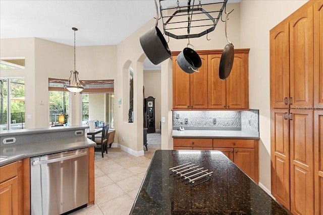 4080 Safflower Ter, Oviedo, FL 32766 - kitchen with stainless steel dishwasher, backsplash, arched walkways, hanging light fixtures, and light tile patterned floors