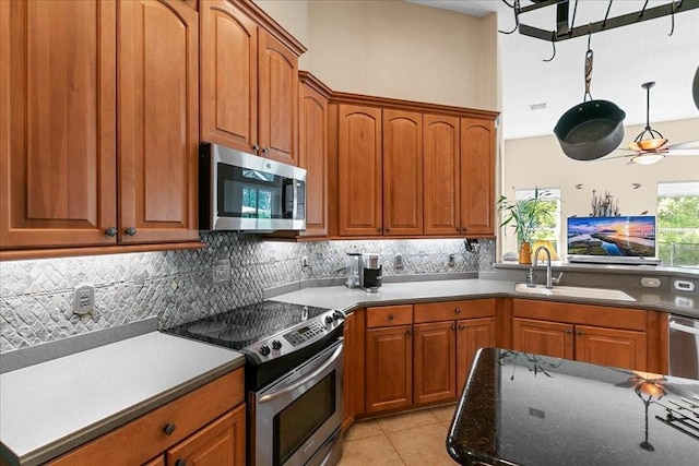 4080 Safflower Ter, Oviedo, FL 32766 - kitchen featuring stainless steel appliances, tasteful backsplash, brown cabinets, and light tile patterned floors