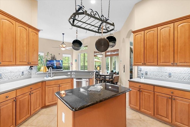 4080 Safflower Ter, Oviedo, FL 32766 - kitchen with stainless steel dishwasher, light tile patterned floors, decorative backsplash, arched walkways, and a center island