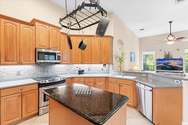 4080 Safflower Ter, Oviedo, FL 32766 - kitchen featuring stainless steel appliances, a peninsula, light tile patterned floors, and tasteful backsplash