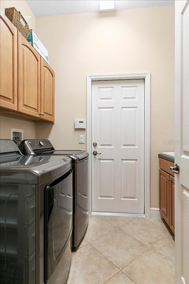 4080 Safflower Ter, Oviedo, FL 32766 - laundry room with independent washer and dryer, cabinet space, and light tile patterned flooring