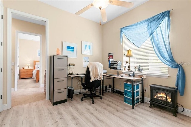4080 Safflower Ter, Oviedo, FL 32766 - office space with a wood stove, light wood finished floors, and ceiling fan