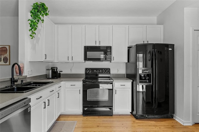 14466 Bridgewater Crossings Blvd, Windermere, FL 34786 - kitchen featuring black appliances, white cabinets, and light wood finished floors