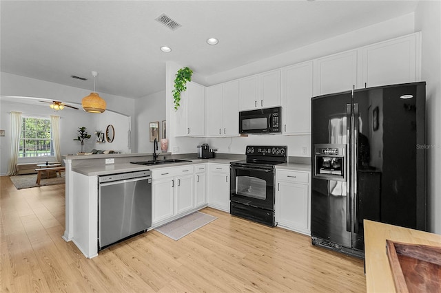 14466 Bridgewater Crossings Blvd, Windermere, FL 34786 - kitchen featuring black appliances, white cabinets, light wood finished floors, a peninsula, and recessed lighting