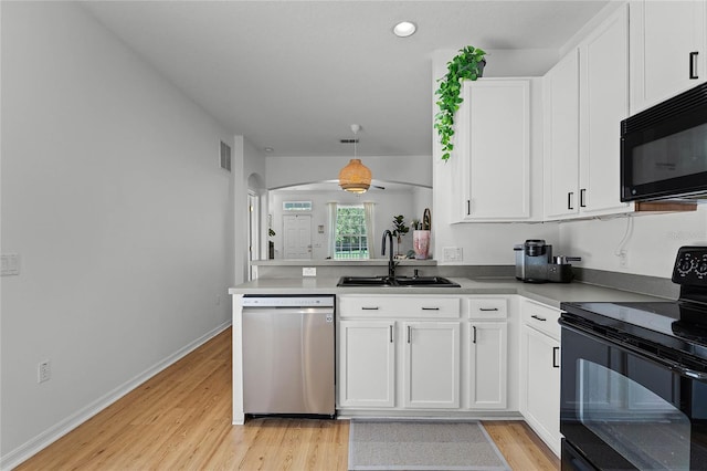 14466 Bridgewater Crossings Blvd, Windermere, FL 34786 - kitchen with black appliances, light wood-style floors, white cabinets, a peninsula, and arched walkways