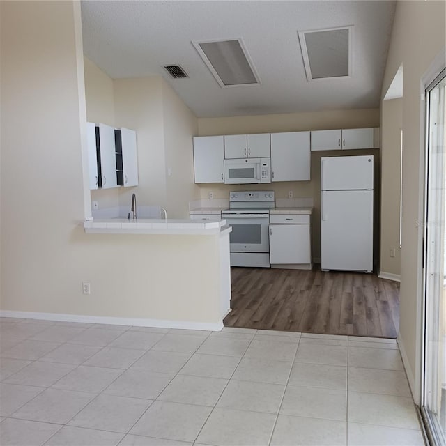 289 White Marsh Cir, Orlando, FL 32824 - kitchen with white appliances, light countertops, a peninsula, and light tile patterned floors