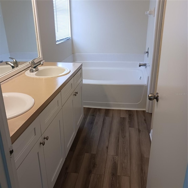 289 White Marsh Cir, Orlando, FL 32824 - bathroom featuring a garden tub, double vanity, and wood finished floors