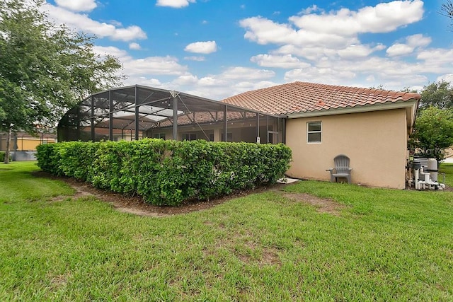 4060 Oak Tree Dr, Davenport, FL 33837 - rear view of house with stucco siding, a tiled roof, a lawn, and a lanai