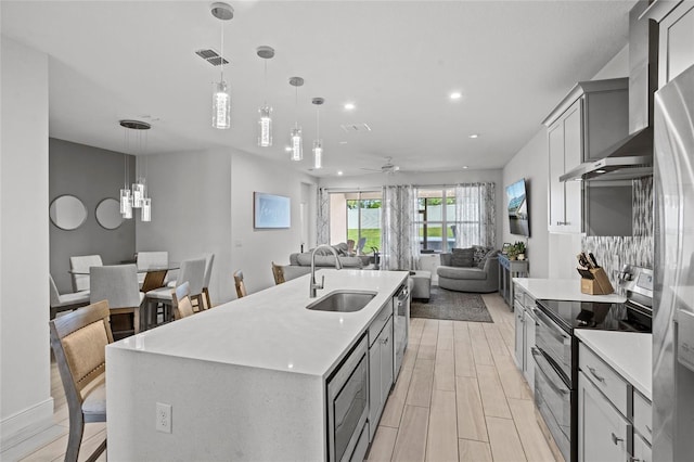 3336 Jackson Bluff Way, Clermont, FL 34711 - kitchen with appliances with stainless steel finishes, wall chimney exhaust hood, ceiling fan, light countertops, and recessed lighting