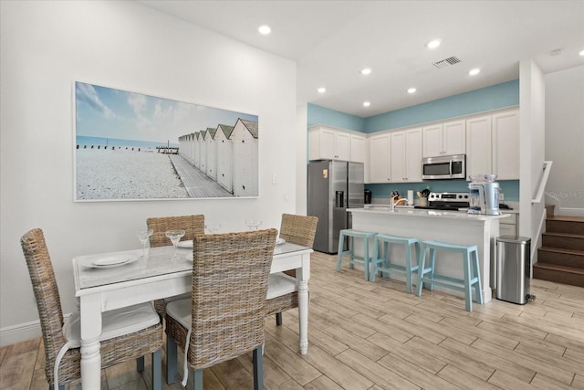 8017 Sandy Toes Way, Kissimmee, FL 34747 - dining space with light wood-style floors, stairway, and recessed lighting