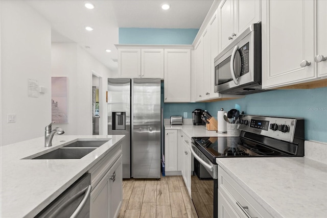 8017 Sandy Toes Way, Kissimmee, FL 34747 - kitchen featuring stainless steel appliances, recessed lighting, white cabinets, and light wood-style floors
