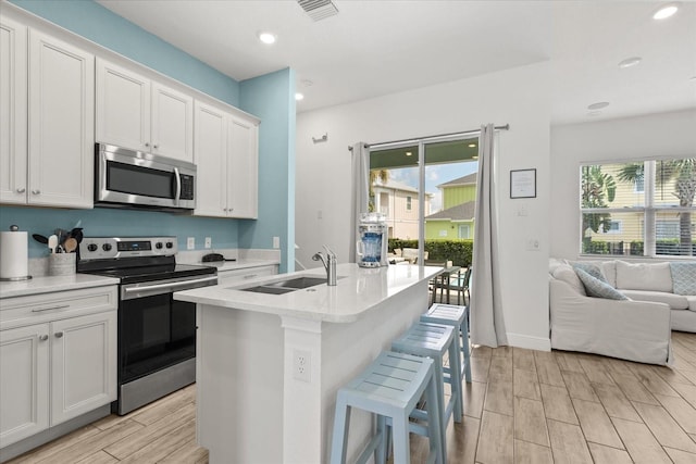 8017 Sandy Toes Way, Kissimmee, FL 34747 - kitchen with appliances with stainless steel finishes, open floor plan, wood finish floors, light countertops, and recessed lighting
