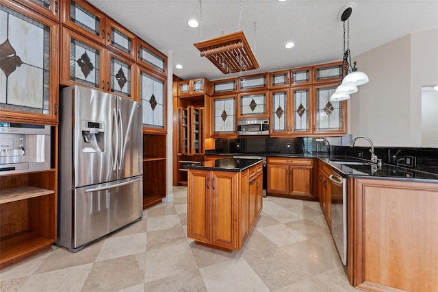 11031 Ledgement Ln, Windermere, FL 34786 - kitchen with appliances with stainless steel finishes, a kitchen island, dark countertops, brown cabinets, and glass insert cabinets