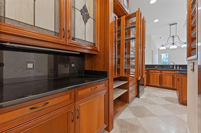 11031 Ledgement Ln, Windermere, FL 34786 - kitchen featuring brown cabinets, tasteful backsplash, decorative light fixtures, glass insert cabinets, and recessed lighting
