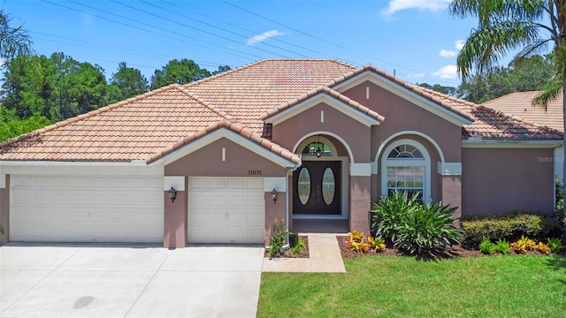 11031 Ledgement Ln, Windermere, FL 34786 - mediterranean / spanish-style home featuring driveway, a tile roof, stucco siding, and a garage