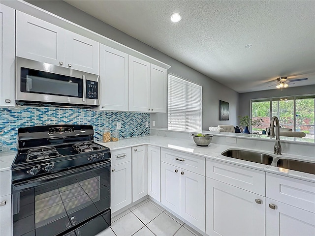 5754 Magnolia Bloom Ter, Oviedo, FL 32765 - kitchen featuring black gas stove, stainless steel microwave, a textured ceiling, white cabinetry, and ceiling fan