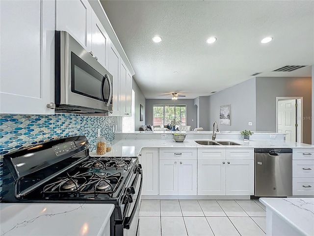 5754 Magnolia Bloom Ter, Oviedo, FL 32765 - kitchen with stainless steel appliances, a textured ceiling, light stone countertops, white cabinetry, and decorative backsplash