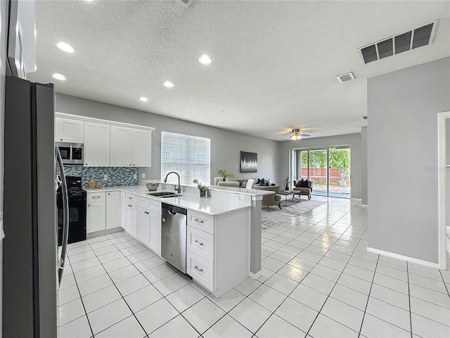 5754 Magnolia Bloom Ter, Oviedo, FL 32765 - kitchen featuring stainless steel appliances, open floor plan, a peninsula, a textured ceiling, and light countertops