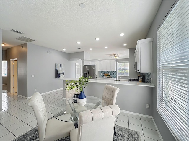 5754 Magnolia Bloom Ter, Oviedo, FL 32765 - dining area with light tile patterned floors, arched walkways, recessed lighting, ceiling fan, and a textured ceiling