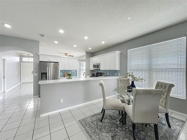 5754 Magnolia Bloom Ter, Oviedo, FL 32765 - dining space with arched walkways, a textured ceiling, a ceiling fan, light tile patterned floors, and healthy amount of natural light