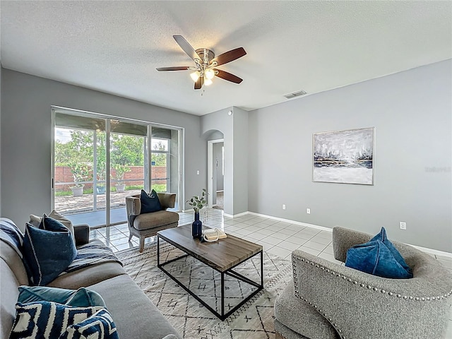 5754 Magnolia Bloom Ter, Oviedo, FL 32765 - living area featuring arched walkways, a ceiling fan, light tile patterned flooring, and a textured ceiling