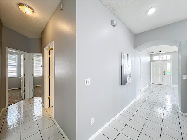 5754 Magnolia Bloom Ter, Oviedo, FL 32765 - hall featuring light tile patterned flooring, arched walkways, and a textured ceiling