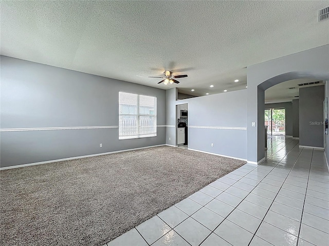 5754 Magnolia Bloom Ter, Oviedo, FL 32765 - spare room with light carpet, arched walkways, a ceiling fan, light tile patterned flooring, and a textured ceiling