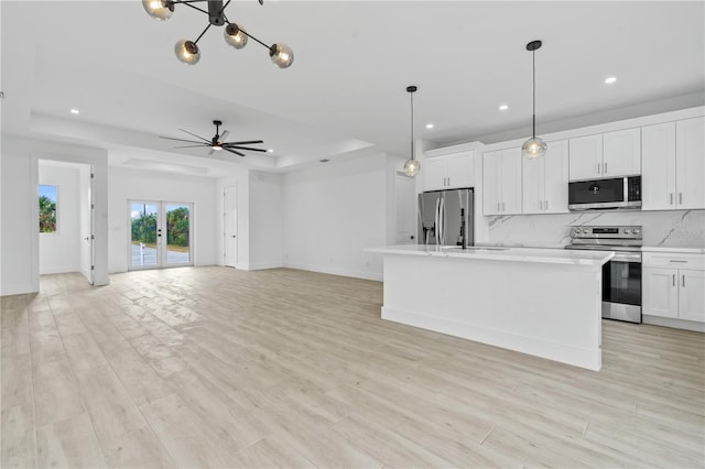 13438 Mcintosh Ave, Port Charlotte, FL 33981 - kitchen with stainless steel appliances, a raised ceiling, decorative backsplash, recessed lighting, and white cabinets