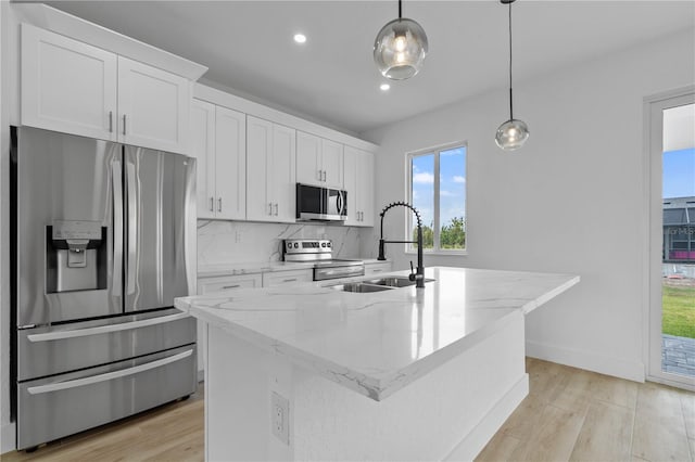 13438 Mcintosh Ave, Port Charlotte, FL 33981 - kitchen with stainless steel appliances, a center island with sink, white cabinetry, light wood-style flooring, and recessed lighting