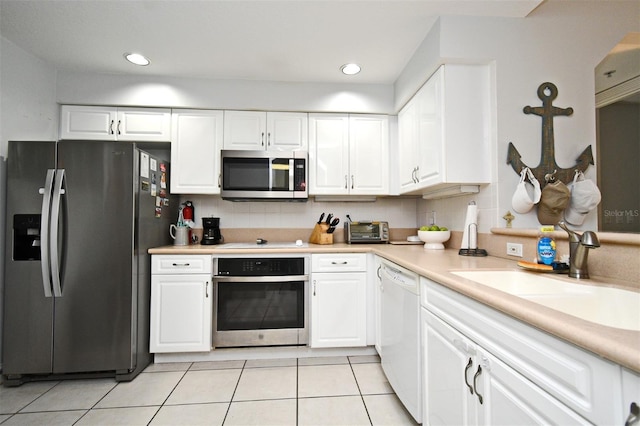 4624 Harbour Village Blvd Unit 4206, Ponce Inlet, FL 32127 - kitchen with appliances with stainless steel finishes, light countertops, white cabinetry, light tile patterned floors, and decorative backsplash