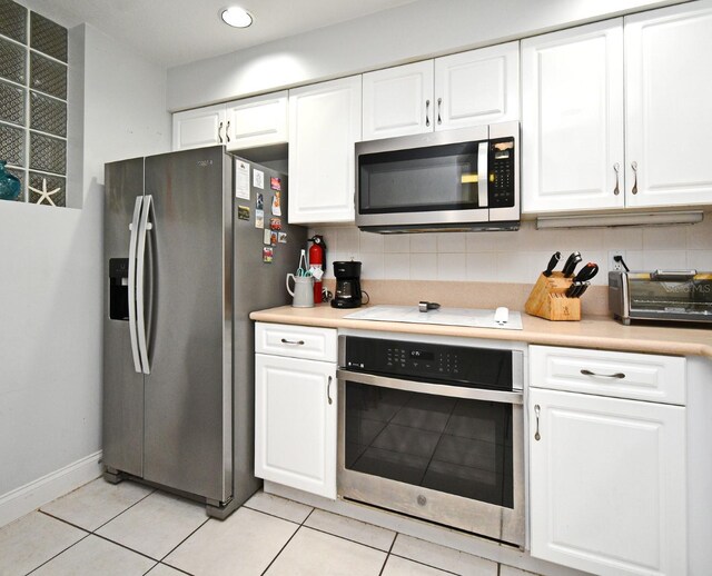4624 Harbour Village Blvd Unit 4206, Ponce Inlet, FL 32127 - kitchen with stainless steel appliances, white cabinets, backsplash, light tile patterned flooring, and recessed lighting