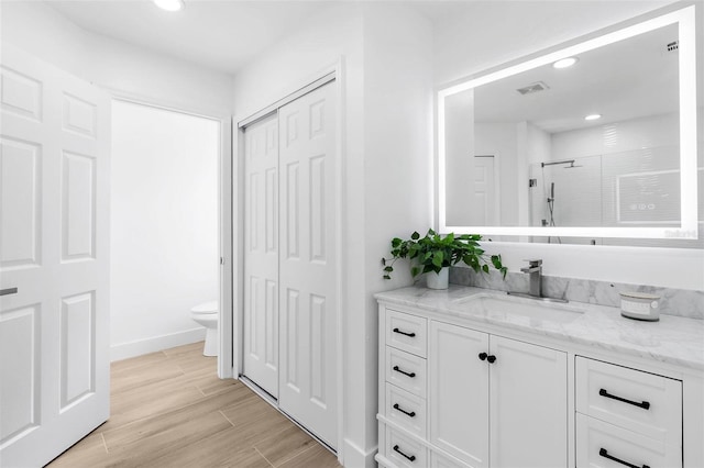 7450 Franzino Ave, North Port, FL 34291 - full bathroom with vanity, an enclosed shower, a closet, recessed lighting, and wood finished floors