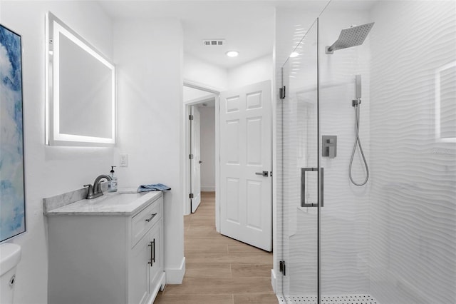 7450 Franzino Ave, North Port, FL 34291 - bathroom featuring vanity, a stall shower, and wood finished floors