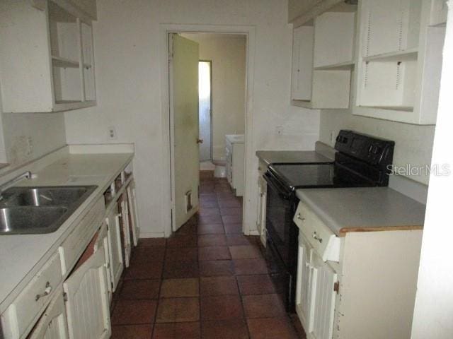 5304 Galloway Rd, Apopka, FL 32712 - kitchen with black / electric stove, white cabinetry, dark tile patterned flooring, and light countertops