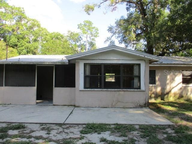 5304 Galloway Rd, Apopka, FL 32712 - back of house featuring a sunroom, a patio area, and a metal roof