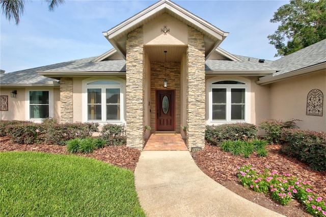 1624 Bear Crossing Cir, Apopka, FL 32703 - property entrance with stucco siding, roof with shingles, and stone siding