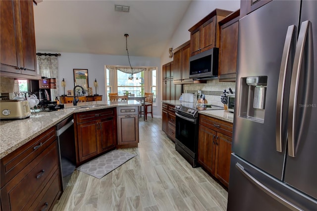 1624 Bear Crossing Cir, Apopka, FL 32703 - kitchen with stainless steel appliances, decorative backsplash, a peninsula, light wood-style floors, and light stone counters