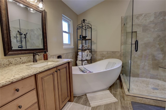1624 Bear Crossing Cir, Apopka, FL 32703 - bathroom with tile walls, a stall shower, a soaking tub, vanity, and vaulted ceiling