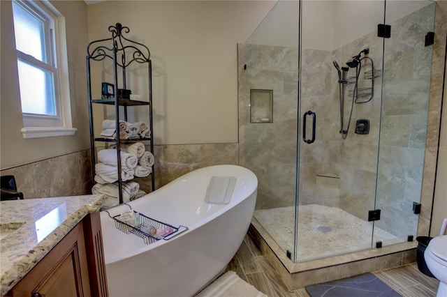 1624 Bear Crossing Cir, Apopka, FL 32703 - bathroom with tile walls, a freestanding tub, vanity, a stall shower, and a wainscoted wall