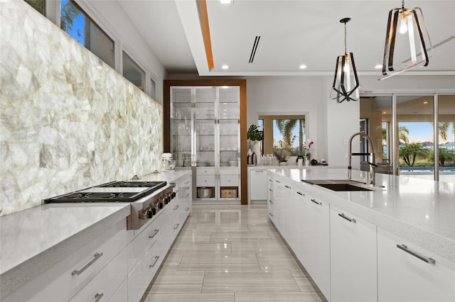 12264 Montalcino Cir, Windermere, FL 34786 - kitchen with stainless steel gas cooktop, decorative backsplash, white cabinets, healthy amount of natural light, and recessed lighting