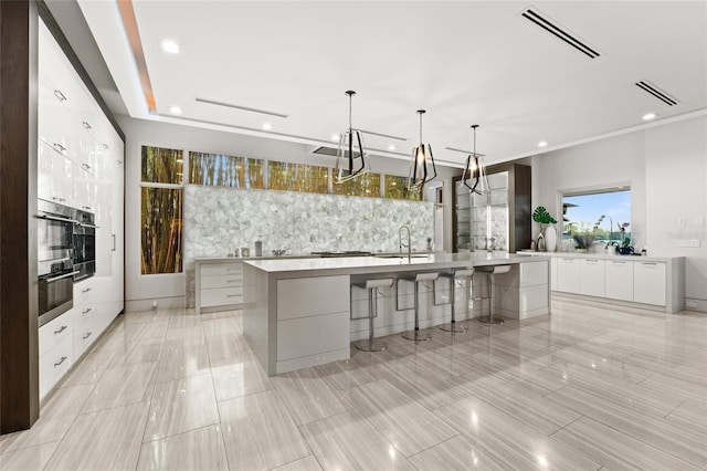 12264 Montalcino Cir, Windermere, FL 34786 - kitchen with modern cabinets, a large island, white cabinetry, light countertops, and recessed lighting