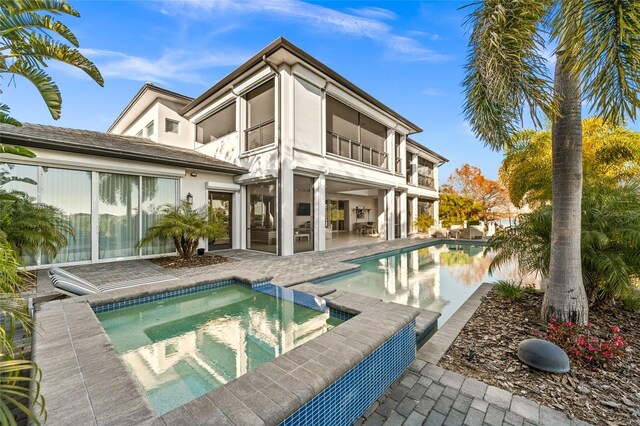 12264 Montalcino Cir, Windermere, FL 34786 - back of house featuring a balcony, a patio, stucco siding, and a pool with connected hot tub