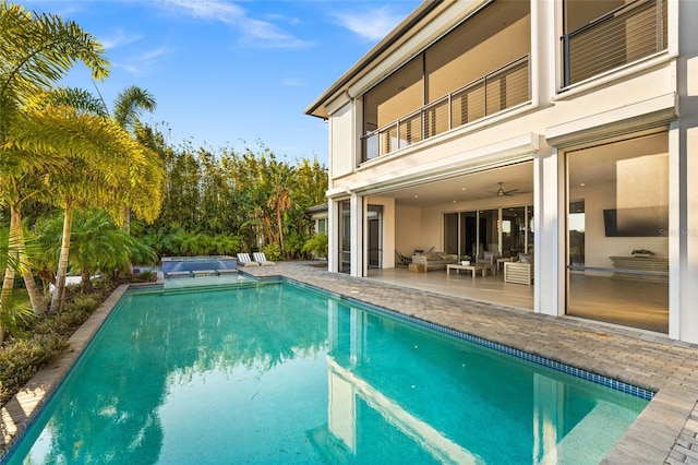 12264 Montalcino Cir, Windermere, FL 34786 - back of house with an outdoor hangout area, a patio, an outdoor pool, a balcony, and a hot tub