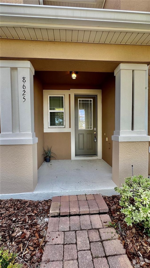 8625 Coventry Park Way, Windermere, FL 34786 - view of exterior entry with stucco siding and a porch